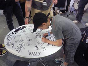 Finley Mapelstone signing the giant Hall of Fame Drum Head for Shine Drums at the London Drum Show 2010